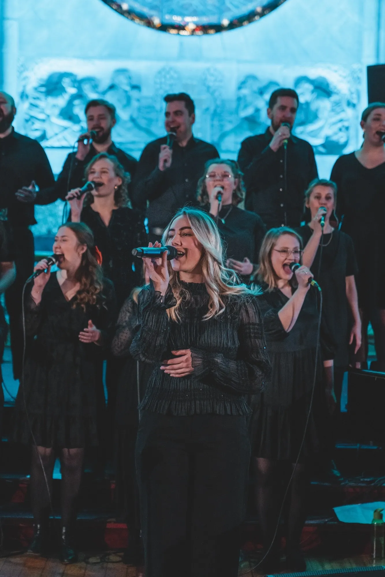 Mosaic synger på konsert, med en solist foran koret